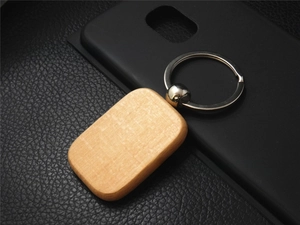 Detail view of rectangular beech wood keychain with rounded edges and silver metal ring