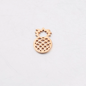 Detailed close-up of a hollow pineapple charm in golden mirror-polished stainless steel
