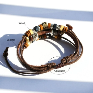 Detail of adjustable multilayer leather bracelet with wood beads and vintage metal charms
