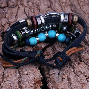 Detail of multi-layer leather bracelet with turquoise beads on natural bark background