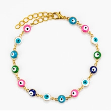 Detailed macro view of the gold chain bracelet featuring colorful evil eye beads and clasp