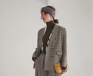 Close-up of grey knitted wide headband paired with vintage British plaid wool suit
