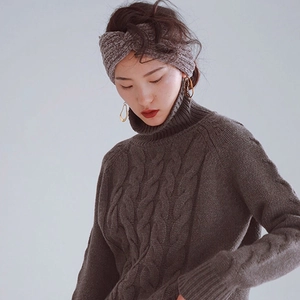 Detail of the chunky cable knit texture on a coffee brown winter headband and sweater