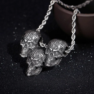 Punk style stainless steel necklace featuring three skull pendants on a vintage twist chain