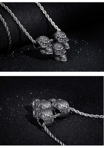 Detailed macro view of triple skull pendant in silver steel with a twist rope chain