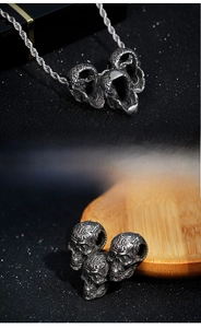 Detailed relief of vintage punk skull pendant with textured stainless steel rope chain