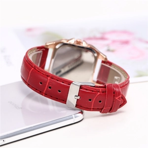 Detail of red leather strap and rose gold buckle of a diamond-encrusted quartz watch