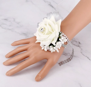 Detail of bridal wrist corsage with white silk rose, silver ribbon and crystal bracelet