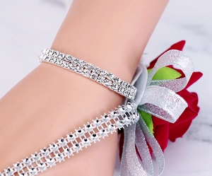 Detail of red rose wrist corsage with double-row crystal rhinestone bracelet and ribbon