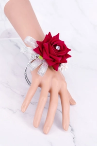 Close-up of red rose wrist corsage with silver glitter ribbon and crystal accents