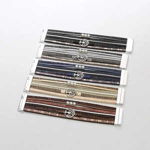 Detail view of multi-layer leather bracelets with tree of life charms and magnetic clasps