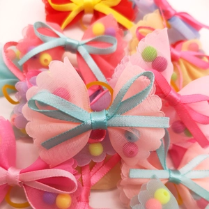 Close-up of colorful pet hair bows with mesh ribbons, satin details and bright beads