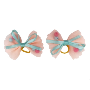 Detail of pink mesh pet hair bows with colorful beads and blue ribbon accents