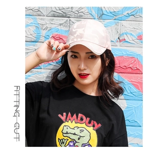 Close-up of pink camouflage baseball cap worn by model against a street graffiti wall