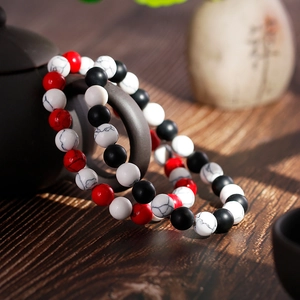 Beaded couple bracelets with 8mm agate and turquoise stones on a dark ceramic pot