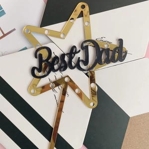 Detailed view of a gold mirror acrylic star cake topper with Best Dad lettering for Father's Day