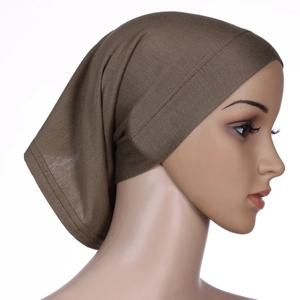 Close-up of brown mercerized cotton stretch turban cap showing soft fabric texture on model