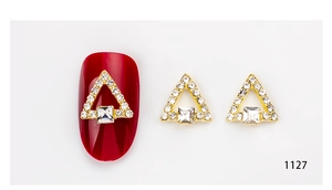 Detailed view of 3D triangle nail art charms with golden finish and clear crystals