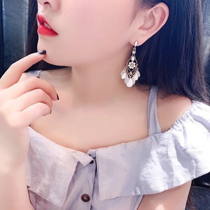 Vintage gold-tone flower earrings with white teardrop tassels and crystal rhinestones