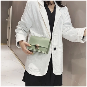 Détail d'un sac bandoulière vert menthe avec boucle dorée porté par un mannequin femme