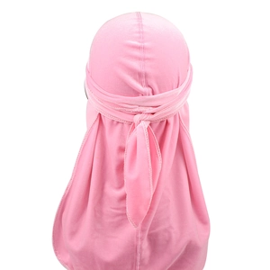 Rear view of vibrant pink velvet durag showing long tail and silky elastic fabric texture
