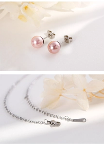 Detail of pink pearl earrings and stainless steel chain necklace set with flowers