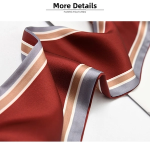 Detail of burgundy satin scarf fabric with striped edges and smooth glossy texture