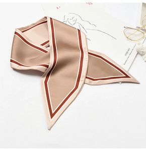Detail of champagne satin twilly scarf with stripe trim wrapped as a bag handle accessory