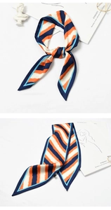 Detail of silk scarf with navy, orange, and cream stripes tied and flat layout