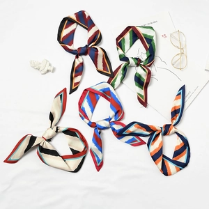 Five assorted retro striped silk scarves tied in bows on a stylish white background