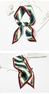 Close-up of tricolor striped twill silk scarf in green and navy with burgundy edges