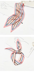 Detail showing pink and blue striped silk scarf with belt buckle print tied in a bow