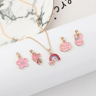 Pink cartoon pendants set with rabbit, unicorn, and rainbow on golden necklace chain