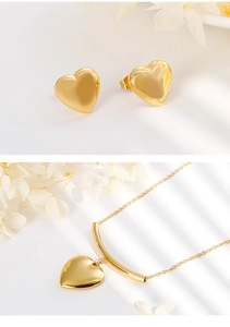 Close-up of polished gold heart necklace and earring set with dry flower decor