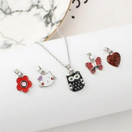 Detail of colorful enamel cartoon pendants including flower and kitty charms for girls