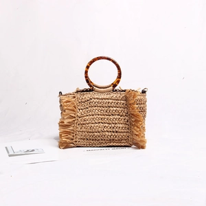 Detailed straw woven handbag featuring tortoiseshell acrylic ring handles and side tassels