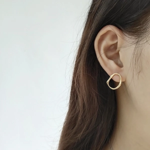 Close-up of irregular 925 silver earring in 18K gold finish on ear model