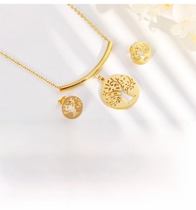 Detail of gold tree of life jewelry set including necklace and earrings on white background