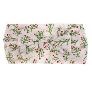 Close-up detail of a soft nylon baby headband featuring a floral berry print and a central bow