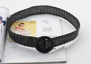 Détail d'une ceinture tressée noire avec boucle ronde mate sur magazine de mode
