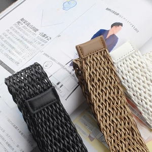 Détail de ceintures tressées en noir, marron et blanc avec des extrémités en cuir