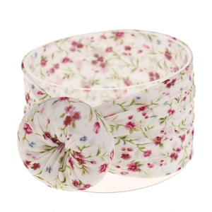 Detalle de una diadema de nailon floral con flores rosas y un nudo redondo fruncido