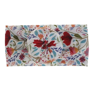 Primer plano del estampado floral bohemio y el suave nudo de bola en la diadema.