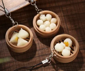 Macro shot of realistic dim sum keychains including shrimp dumplings and shaomai in steamers