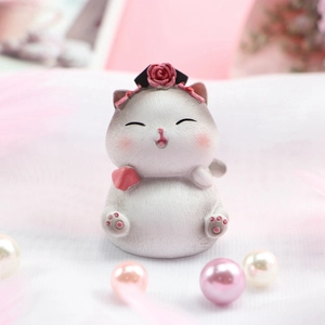 Nahaufnahme der Retro-Katzenfigur mit rosa Rosen-Kopfschmuck und Pfotendetails