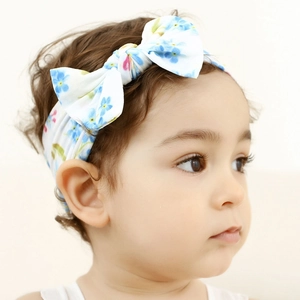 Detail shot of a baby nylon headband with blue floral print on a child model