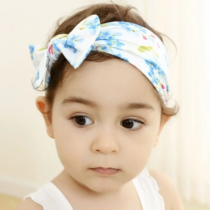 Close-up of a cute baby girl wearing a floral printed nylon headband with a bow
