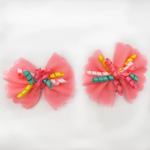Close-up of pink lace dog hair bows with colorful curly ribbons and mesh texture