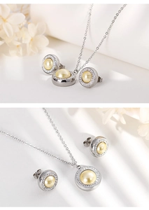 Detail of silver pearl necklace and earrings set with crystal halo on white background