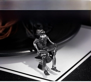 Macro shot of unique silver skull skeleton sitting on toilet pendant necklace for men